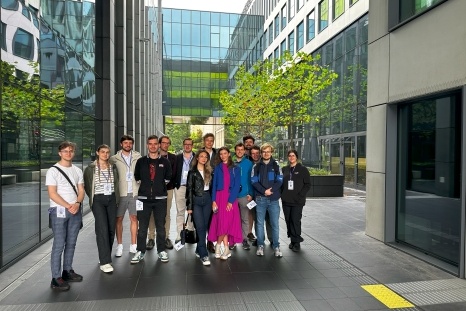 Gruppe von Menschen steht in einem modernen, urbanen Außenbereich.