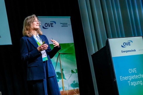 Eine Frau präsentiert auf einer Konferenz zur Energietechnik vor einem Publikum.