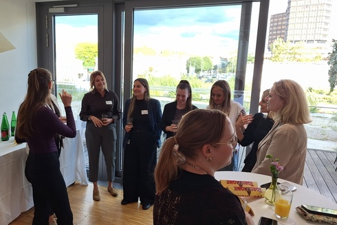 Gruppengespräch von Frauen bei einem Event in einem hellen Raum.