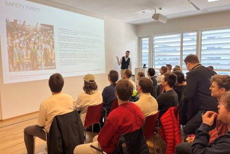 Ein Referent spricht vor einer Gruppe von Menschen über Sicherheit.