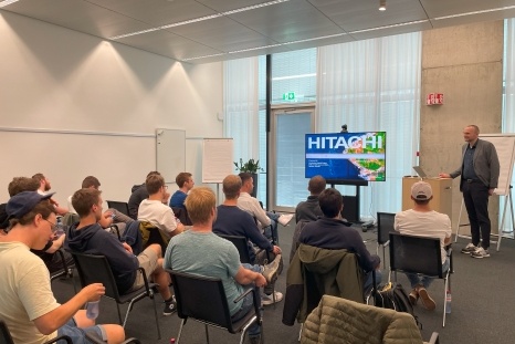 Präsentation eines Sprechers vor einer Gruppe von Zuhörern in einem Konferenzraum.