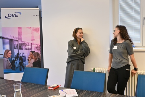 Zwei Frauen unterhalten sich in einem Besprechungsraum.