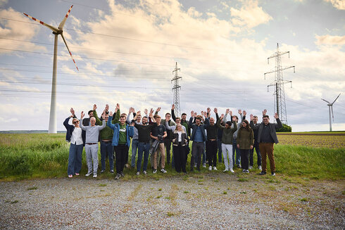Gruppencollage von Menschen, die Welle in einem Feld mit Windrädern machen.
