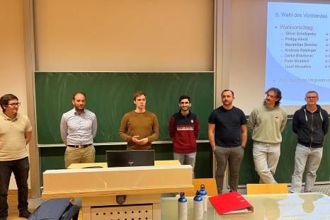 Gruppentreffen zur Wahl des Vorstands mit sieben Personen an einer Tafel.