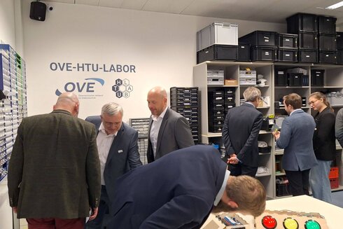 Personen besichtigen das OVE-HTU-Labor und interagieren mit verschiedenen Geräten.