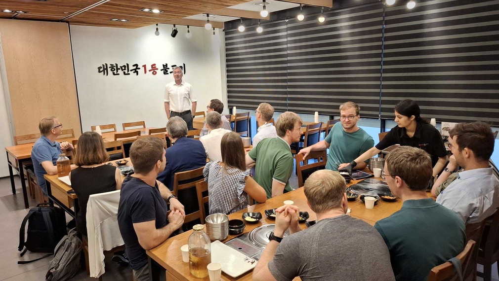 Eine Gruppe von Menschen sitzt an Tischen in einem Restaurant.