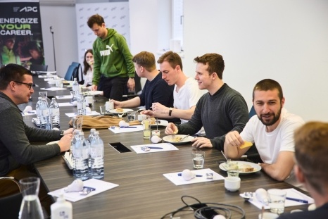 Eine Gruppe von Menschen sitzt an einem Tisch und genießt ein gemeinsames Frühstück.