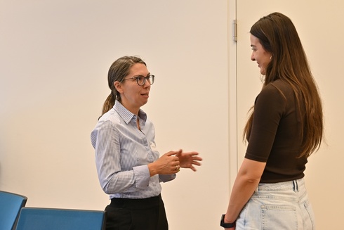 Zwei Frauen führen ein Gespräch in einem Büro.