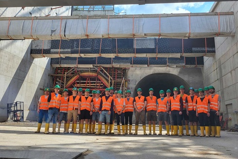 Gruppe von Arbeitern in Sicherheitswesten und Helmen auf einer Baustelle.