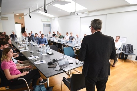 Ein Referent spricht vor einem Publikum in einem Konferenzraum.