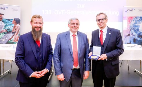 Drei Männer stehen lächelnd zusammen bei der 138. OVE-Generalversammlung.