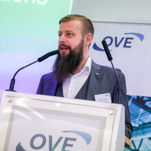 Ein Mann spricht an einem Rednerpult während einer Veranstaltung des OVE.