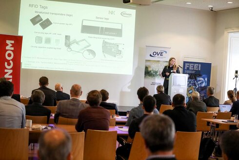 Frauen präsentieren RFID-Technologie vor einem Publikum bei einer Veranstaltung.