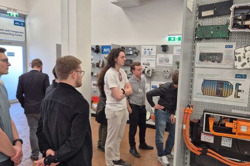 Gruppe von Menschen, die eine technische Ausstellung betrachten.