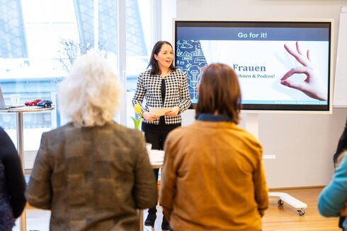 Netzwerktreffen, zwei Frauen von hinten, eine Vortragende