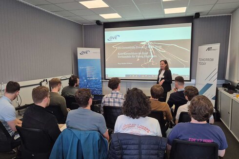 Eine Referentin präsentiert vor einem Publikum in einem Seminarraum.