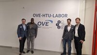 Vier Personen posieren vor dem OVE-HTU-Labor-Schild.