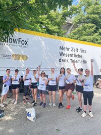 Gruppierung von Menschen in Sportkleidung, die ihre Medaillen nach einem Lauf feiern.