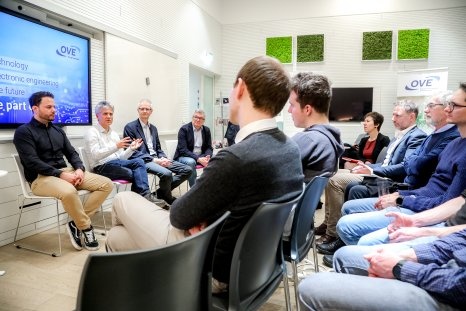 Diskussionsteilnehmer sitzen zusammen und reden über Zukunftsthemen in der Technik.